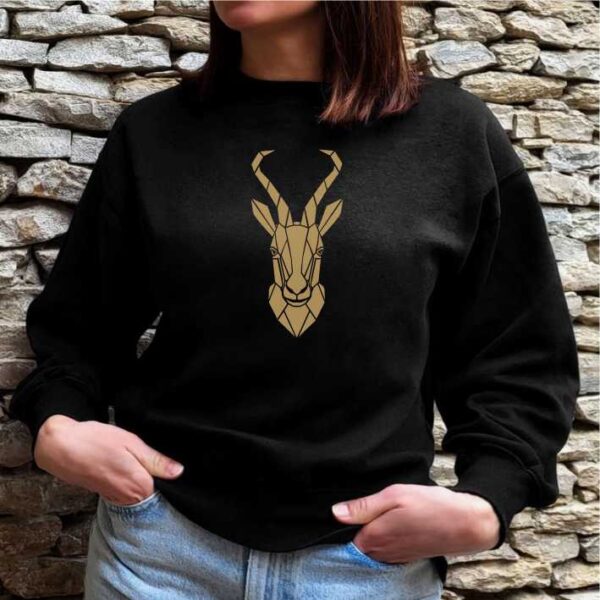 Young man wearing a black sweatshirt with a beautiful gold springbok geometric print. South African clothing.